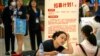 资料照片: 2023年6月9日北京一家购物中心招聘会上一名招聘人员与应聘者交谈