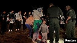 资料照片:一名两岁的中国幼童跟随他的家人渡过美墨边境的格兰德河进入美国德克萨斯州,这家人正在美国边境巡逻人员那里登记以便进入移民程序。(2023年3月23日)