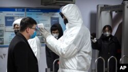 一名乘客星期天（1月26日）在北京地铁接受体温检测。